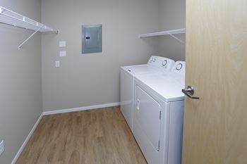 In unit washer and dryer side by side with shelf storage above.